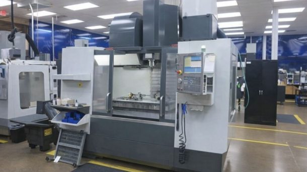 Stor CNC-maskin i en industrilokal, redo för försäljning via auktion.