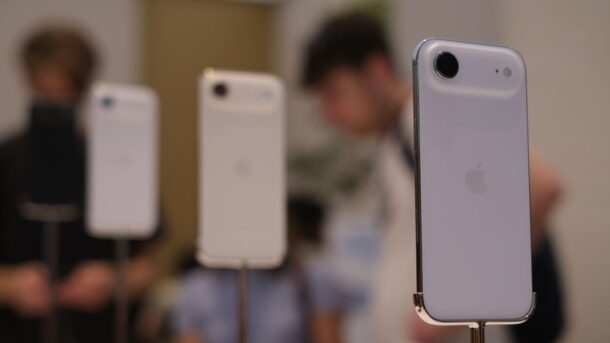 Tre vita iPhone-modeller visas på ställningar i en butiksmiljö