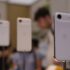 Tre vita iPhone-modeller visas på ställningar i en butiksmiljö