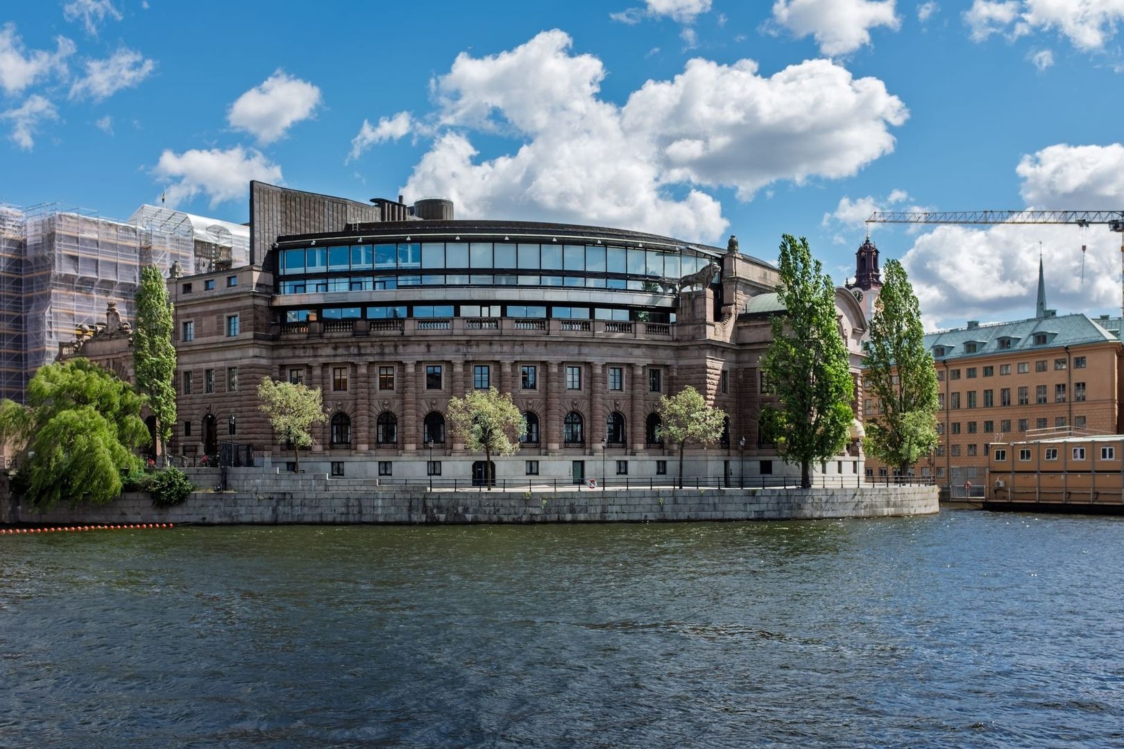 Sveriges riksdagshus vid vattnet under en blå himmel